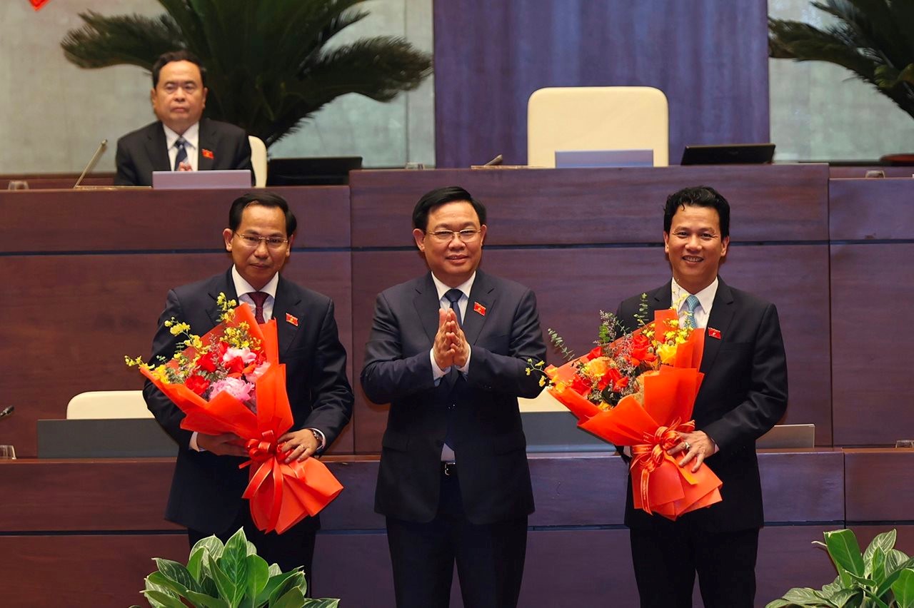 Chủ tịch Quốc hội Vương Đình Huệ tặng hoa tân Bộ trưởng Bộ TN&MT Đặng Quốc Khánh (bên phải) và tân Chủ nhiệm Ủy ban Tài chính – Ngân sách của Quốc hội Lê Quang Mạnh (bên trái). bt1